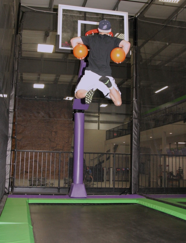 Man Slam Dunking Two Balls on Trampoline Basketball Court